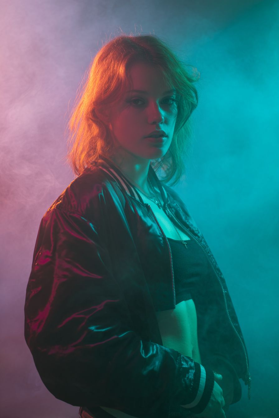 Retrato de estudio de una DJ femenina con chaqueta bomber de satén