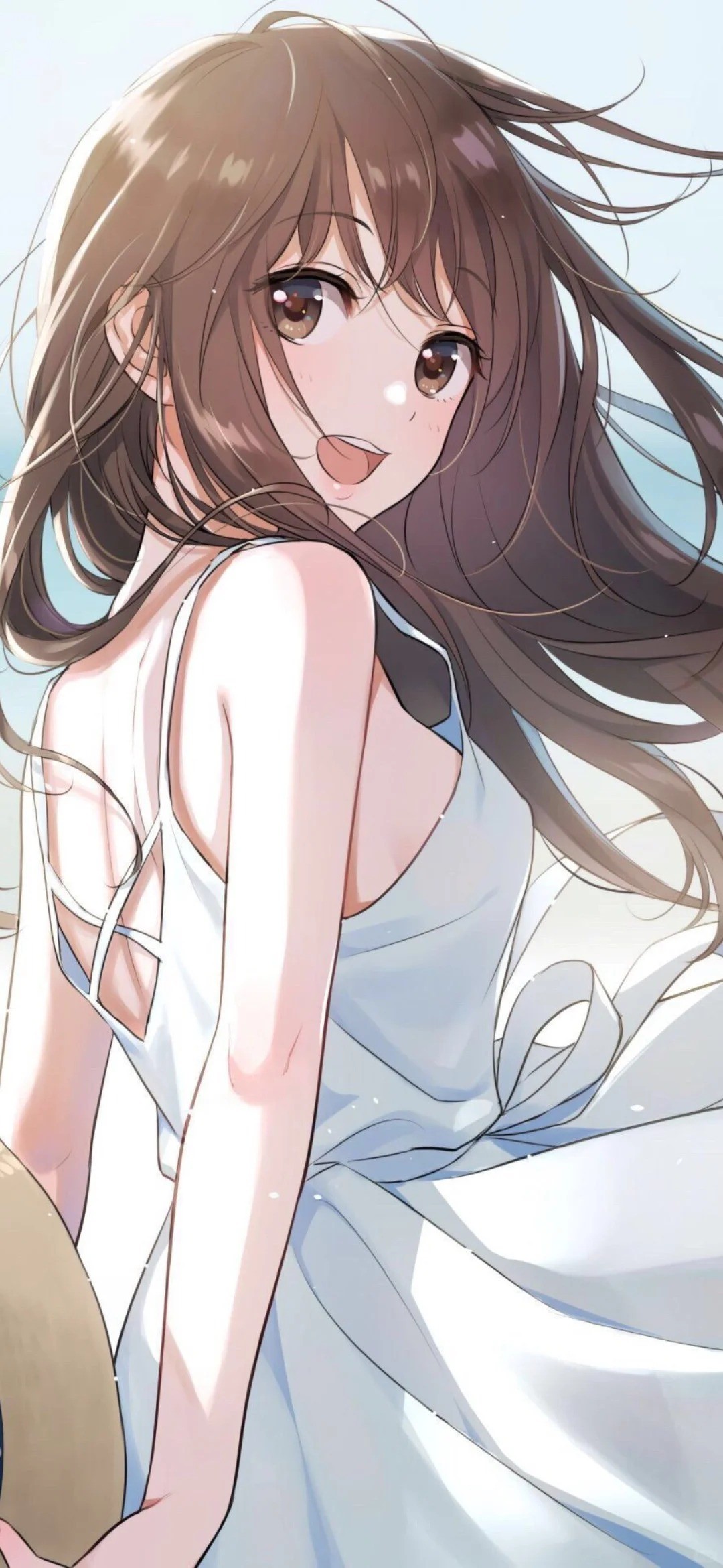 A brown-haired girl in a white backless dress smiles refreshingly by the sea