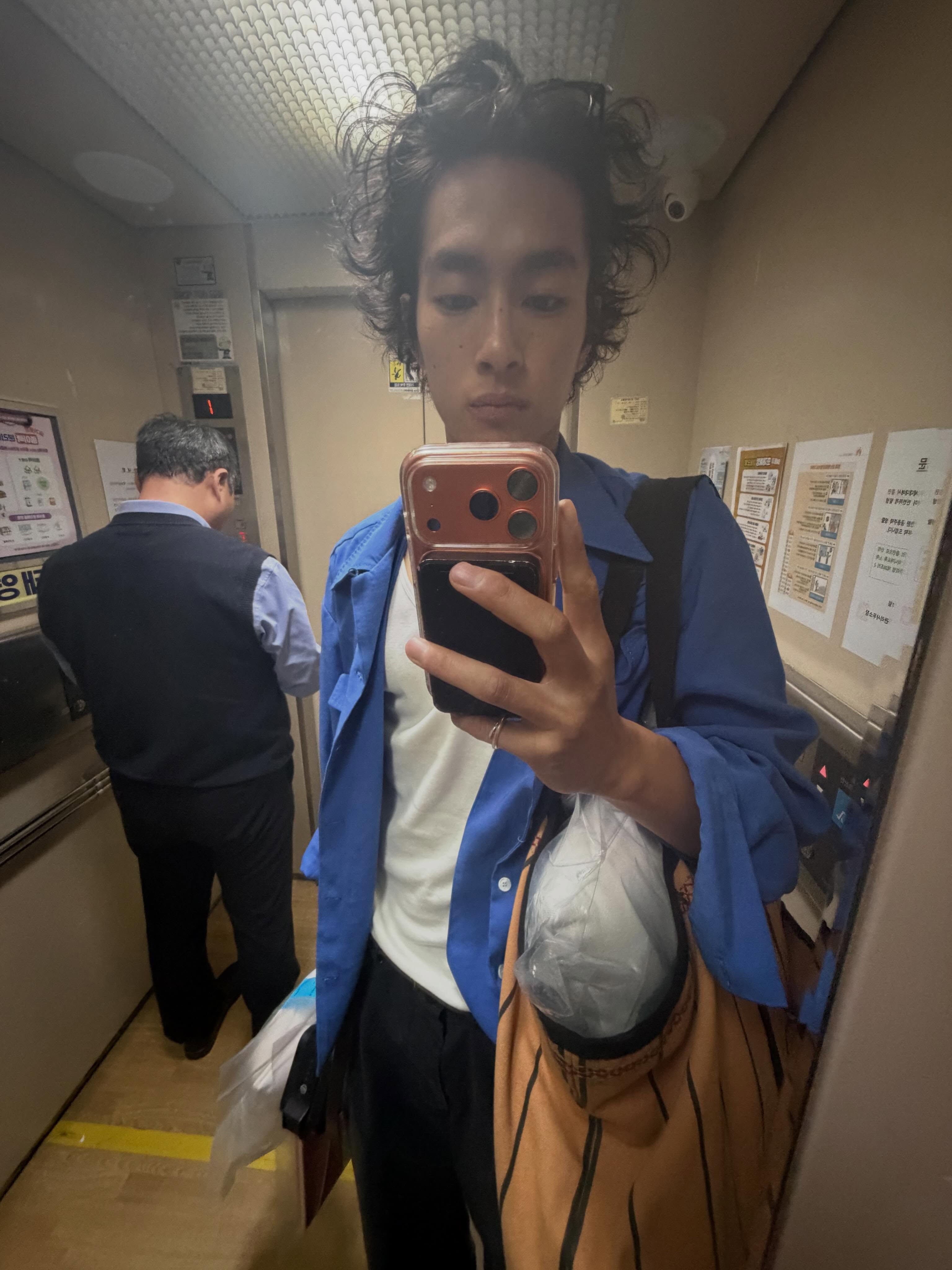 年轻男子穿蓝衬衫白T恤黑裤自拍