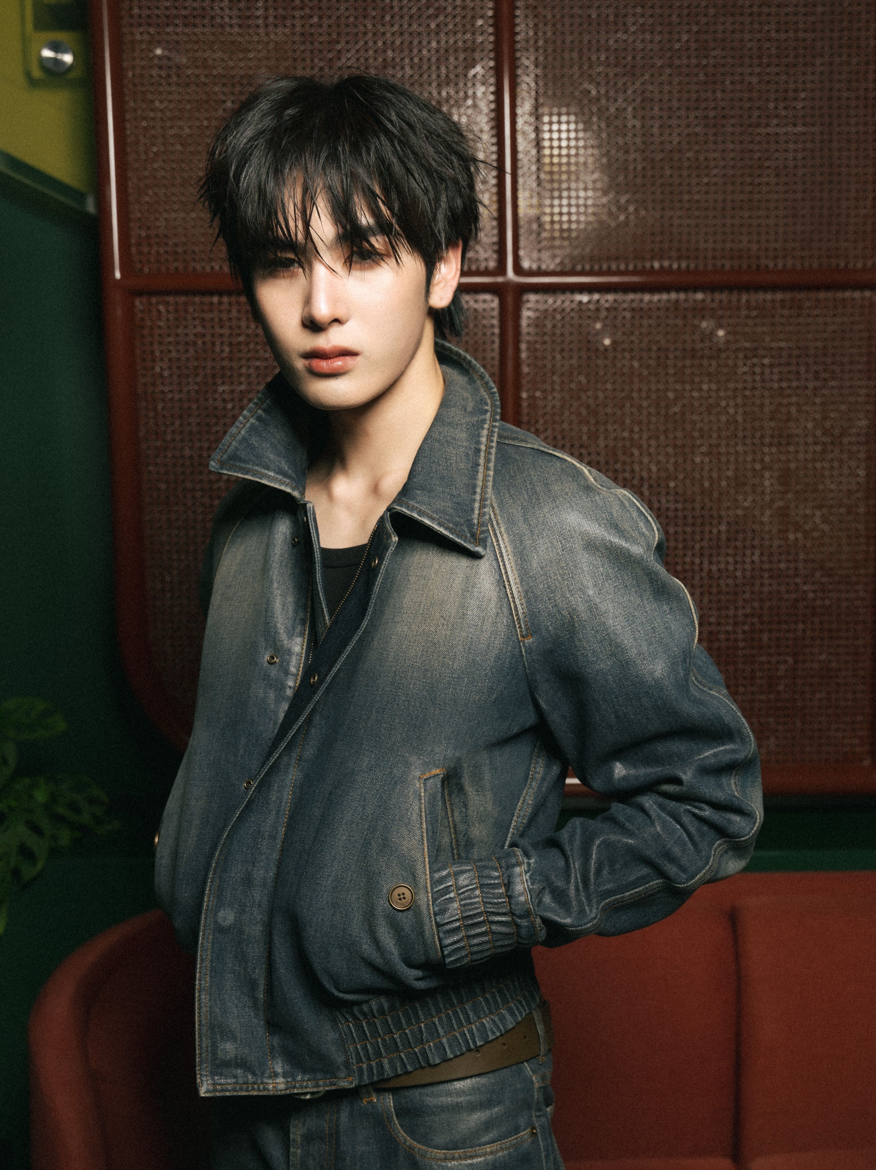 男性がウォッシュデニムジャケットに黒いTシャツを着て落ち着いた雰囲気を表現