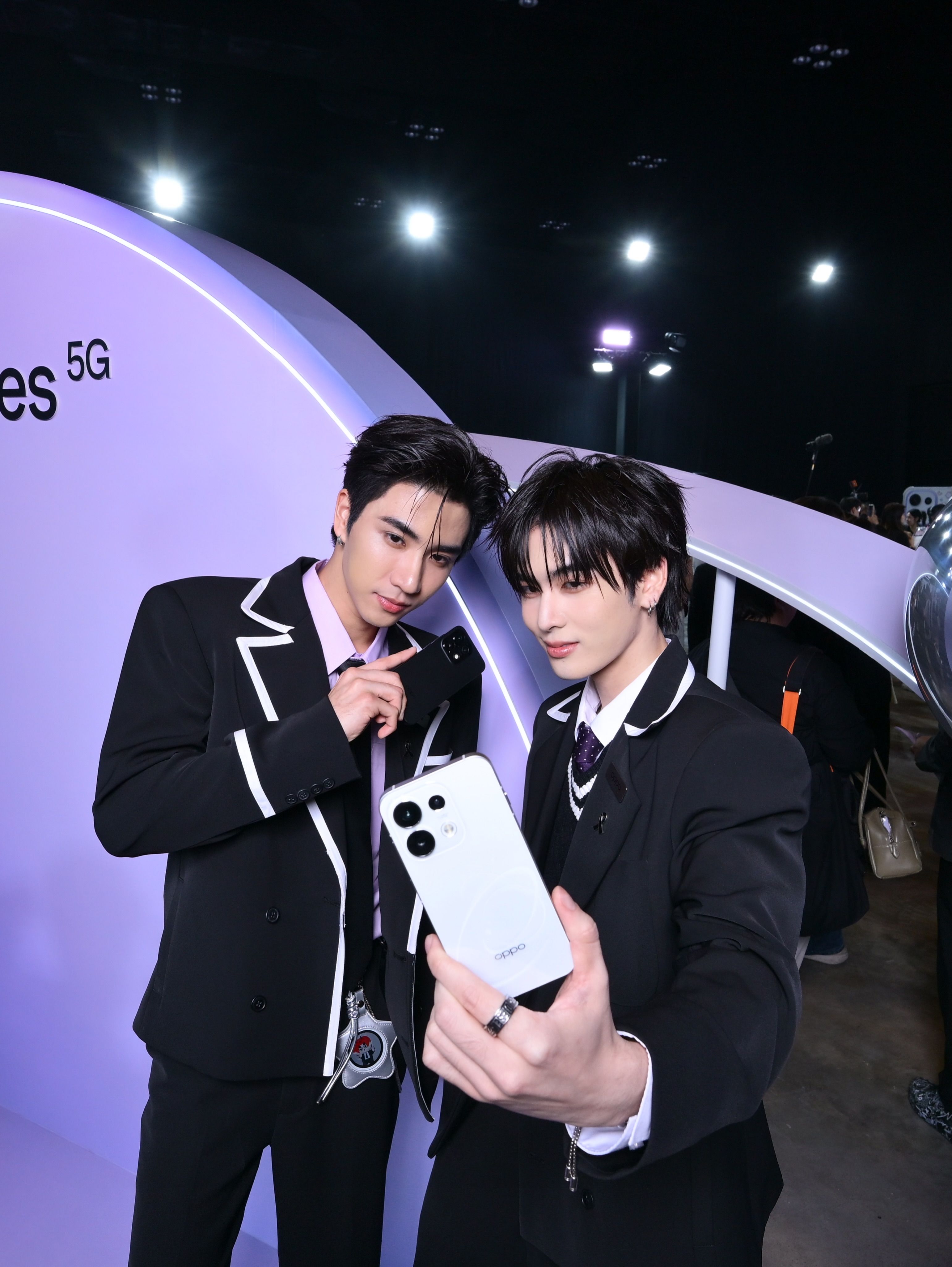Two young men in stylish suits are taking a selfie together